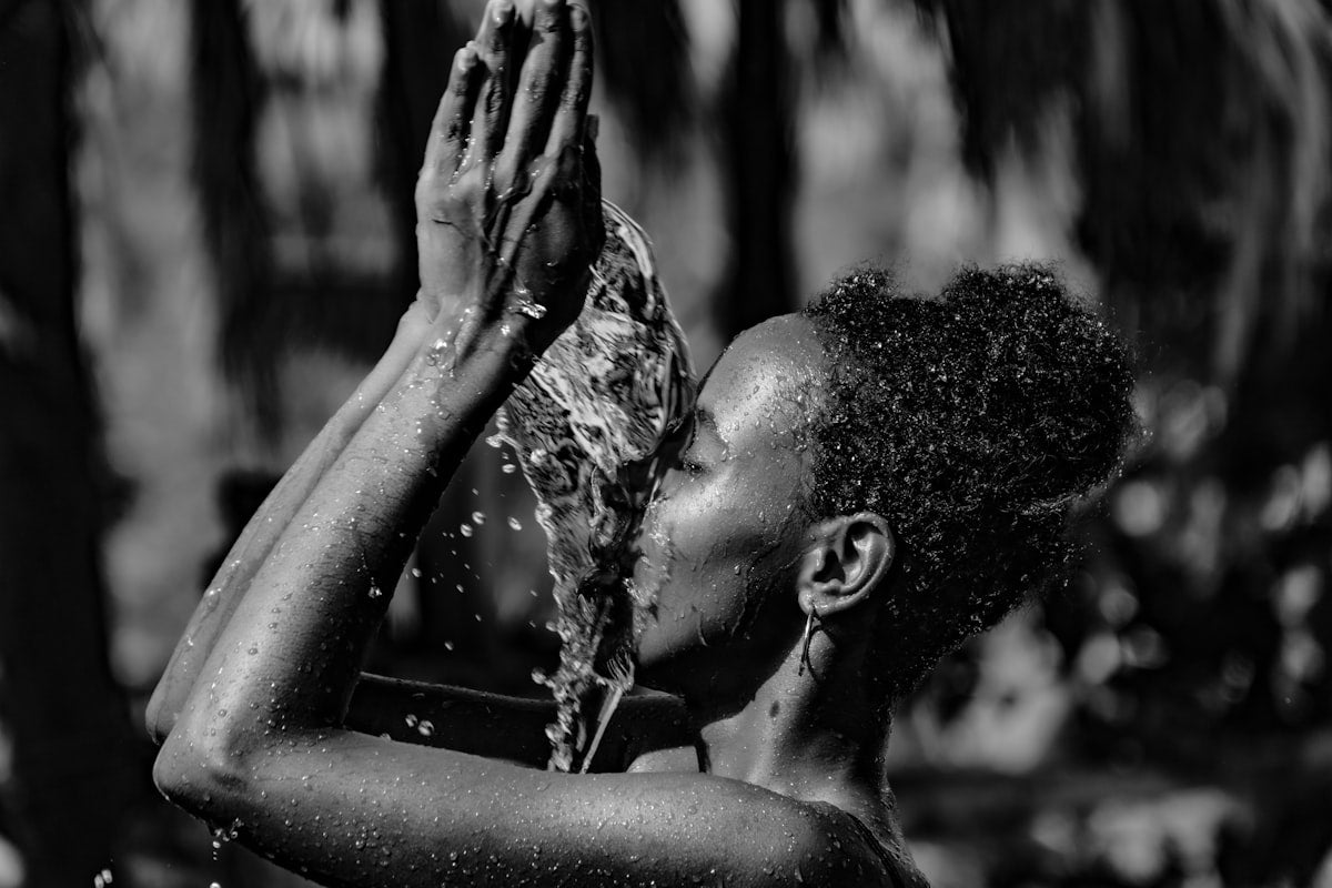 a black and white photo of a woman washing her hands